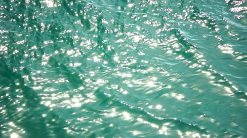 Vue à angle réduit de la surface de l'eau de mer sur l'eau de mer azur clair, éblouissement solaire abstrait, océan d'été