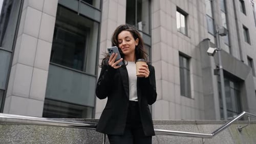 Business Woman Using Smartphone and Drinking Coffee