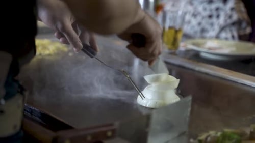 Master chef cutting steaming onion tower in half, Hibachi Restaurant, slowmo HD