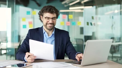 Man Celebrates Success at Modern Office Desk
