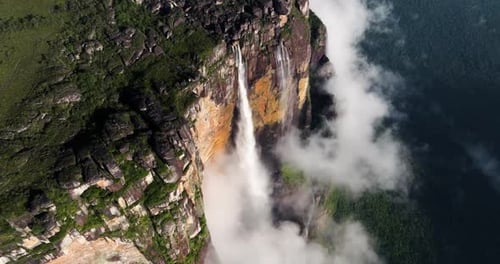 Stunning Aerial View of a Majestic Waterfall Cascading Through Clouds
