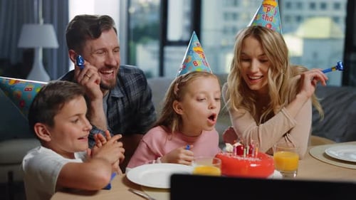 Family Celebrates Birthday Together at Home, Blowing Horns