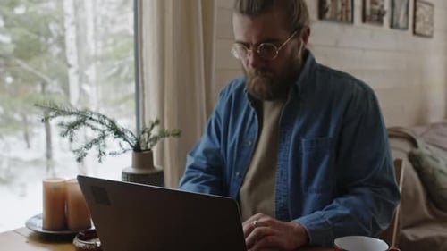 Freelancer masculino abrindo laptop para trabalhar em casa