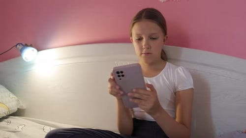 Teen Using Smartphone in Bedroom