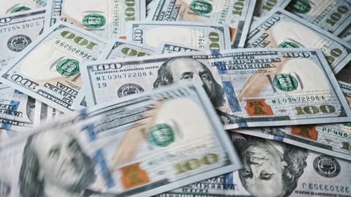 100 Dollar Bills Fall on a Rotating Pile of Dollars CloseUp