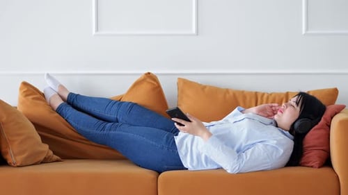 Woman Listening to Music Relaxing on a Couch