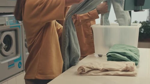 Folding Clean Clothes in Laundromat