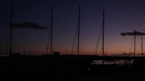 Silhouette sailing pole masts and Portuguese discoverments neon sign at sunset sky and clouds loacat