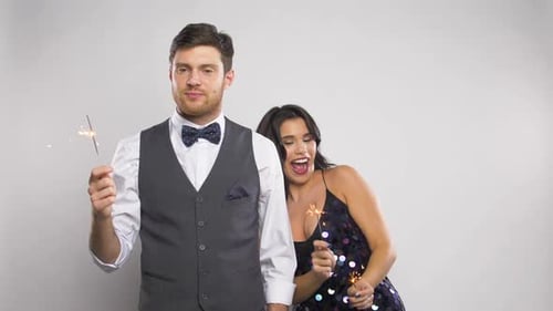 Couple holding sparklers celebrating special occasion indoors