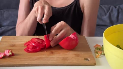 Woman Cuts Fresh Red Tomato on Cutting Board