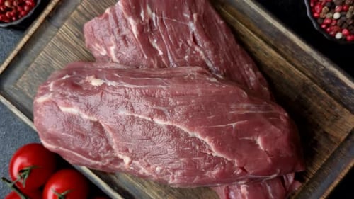 Raw Beef Meat on Cutting Board with Vegetables