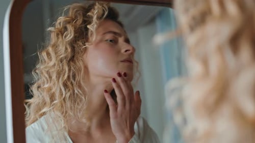 Femme frustrée touchant de l'acné sur une peau à problèmes, gros plan, fille examinant dans un miroir