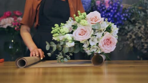 Making a Bouquet in a Flower Shop Closeup of Wrapping a Bouquet in Craft Paper Florist Hands