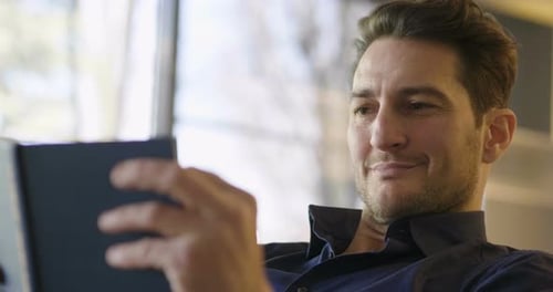 Attractive Man Using Tablet Indoors During Daytime