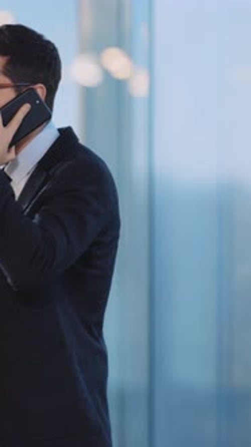 A Businessman in a Suit is Shown Engaged in a Phone Conversation