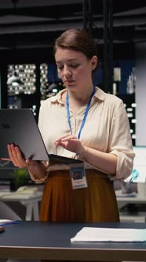 Vertical Video Portrait of Smiling Office Employee Managing Schedules on Laptop
