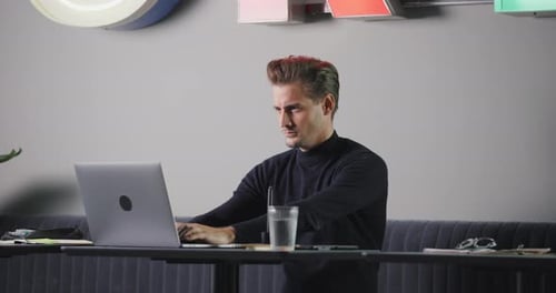 Man working at laptop in modern workplace environment