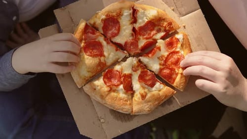 Overhead View of Pizza Slices Being Taken