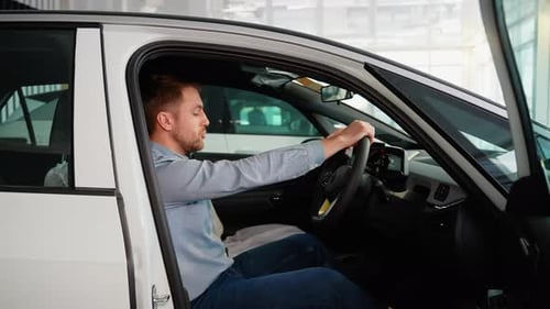 A Cheerful Man Imitates a Car Driving in a Car Dealership Right Hand Drive Car Right Hand Drive Car
