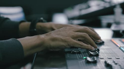 Sound production concept. Sound mixing panel is being regulated by a producer, sound studio