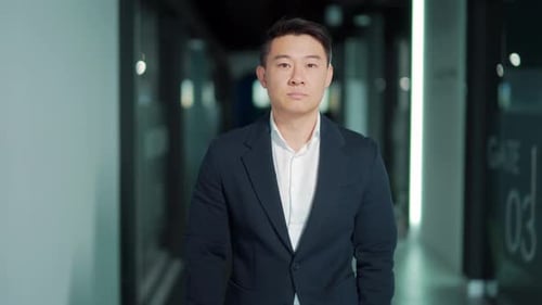 portrait of a successful confident asian male office worker standing and looking at the camera