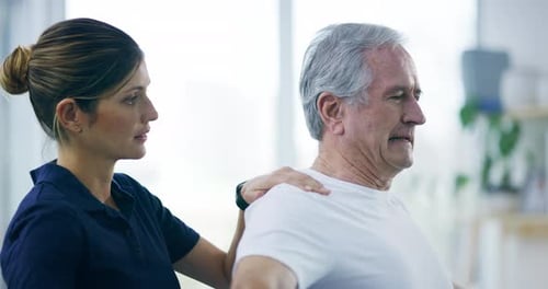 4k video footage of an attractive young female physiotherapist working with a senior male patient