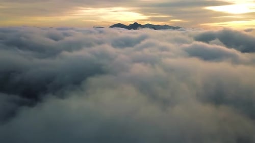 Aerial View of Clouds and Mountain Peaks at Sunset