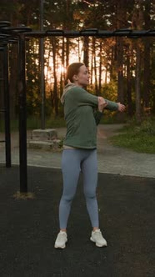Young Woman Stretching her Back and Arms in Forest