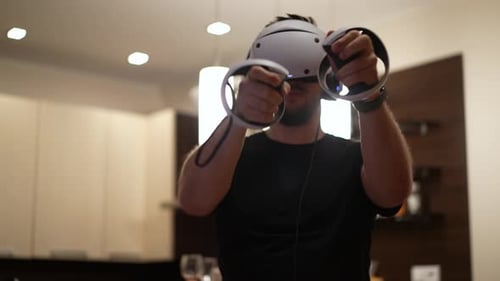 Young Man Playing Virtual Reality Game at Home