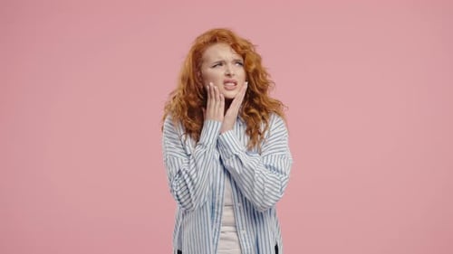Bright Redhaired Woman with Tooth Pain Pink Studio Toothache Dental Problem