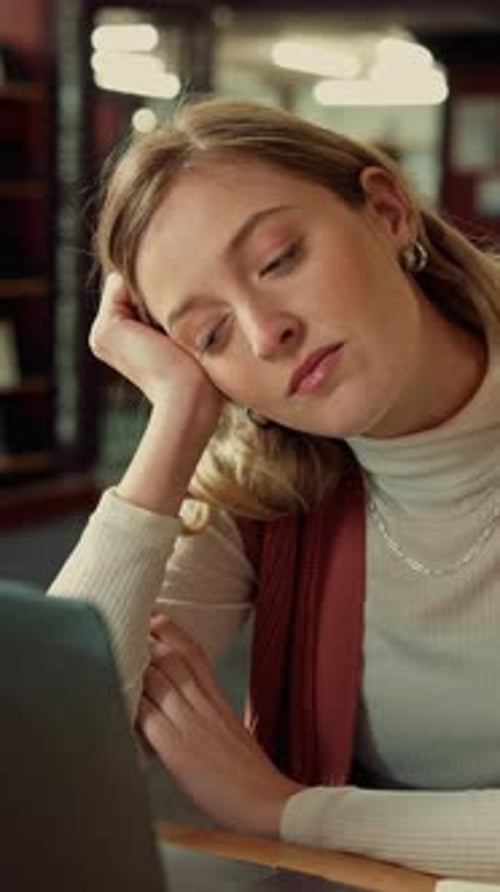 Library, laptop and tired student or woman with internet for research and study burnout