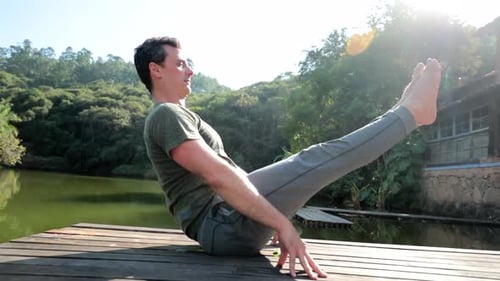 Person training Yoga outdoors. Man practicing exercise in nature