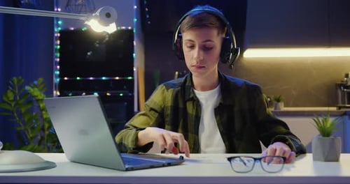 Estudiante inteligente que usa una computadora portátil trabajando en un proyecto escolar, dibujando en un cuaderno con un lápiz