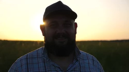 Happy Smiling Farmer in Cap Looks Into Camera Standing at Cultivated Field Portrait of Adult