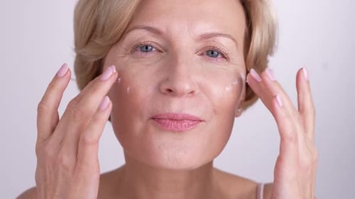 Woman Applies Moisturizer to her Face