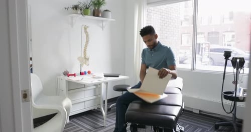 Man reviews paperwork in modern doctor's office