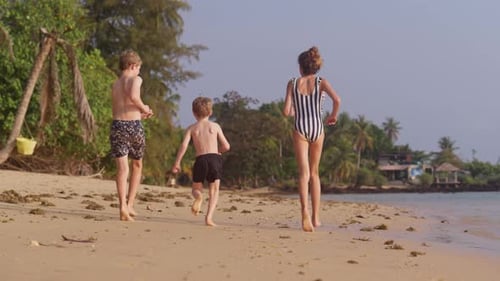 Back View Of Kids Running On The Seashore
