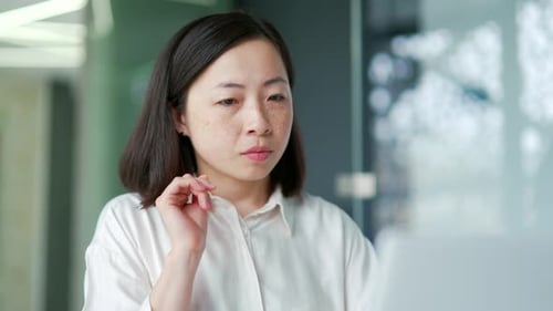 Woman Working on Laptop Computer in Office