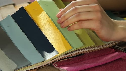 Hands browse colorful textile and leather samples