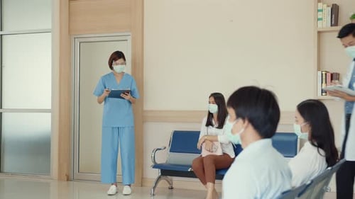 Asian nurse with face masks call group of patients in a waiting room of a hospital.