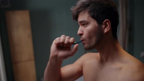 Side View Of Man Brushing His Teeth