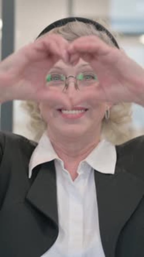 Smiling Senior Woman Making Heart Symbol with Hands