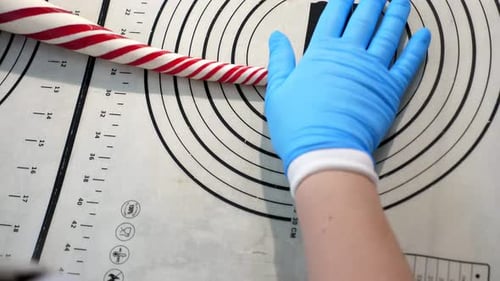 Zwei Konditoren rollen in einer modernen Konditorei weiches Karamell auf den Tisch