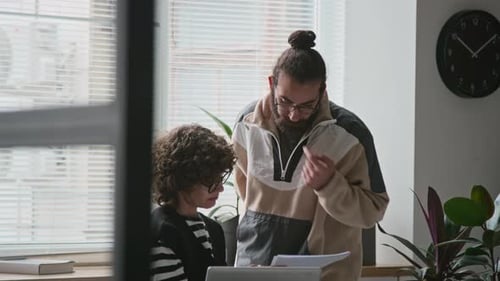 Female Manager and Male Colleague Discussing Documents in Office