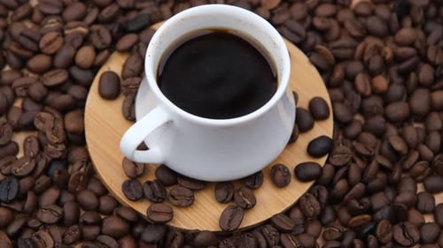 Cup of Coffee Surrounded by Coffee Beans