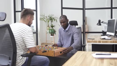 Multiracial Coworkers Playing Table Football in the Office