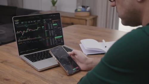 Young Financial Analyst Professional Buy and Sell Crypto on Stock Market Using Laptop Smartphone