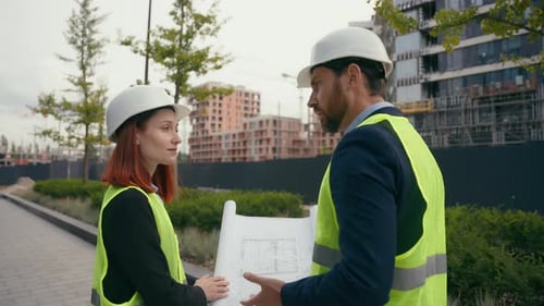Two Contractors Civil Engineers Checking Information in Blueprint Discuss Teamwork Pointing City