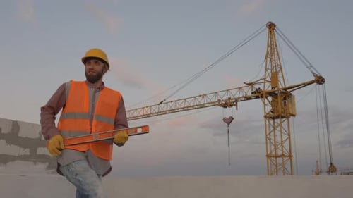 Construction Worker Dancing with Level at Construction Site