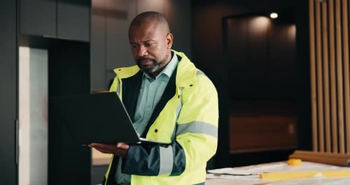 Design, laptop and renovation with black man in kitchen for home improvement or upgrade project